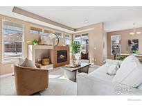 Bright living room with a cozy fireplace, neutral tones, and large windows at 2104 18Th Ave, Longmont, CO 80501