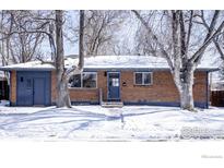 Charming brick ranch-style home with snow-covered yard and mature trees at 2994 23Rd St, Boulder, CO 80304