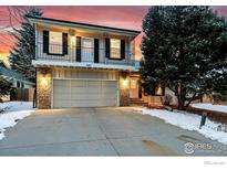 Two-story home with balcony, front-facing garage, set against a dramatic, colorful twilight sky at 440 E Sutton Cir, Lafayette, CO 80026