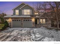 Charming two-story home with a stone facade and attached two-car garage in winter at 4672 Charing Ct, Castle Rock, CO 80109