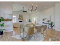 Bright dining room with wood floors, modern chandelier, and neutral color palette at 470 Muirfield Cir, Louisville, CO 80027