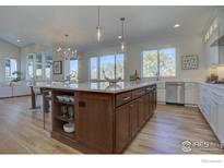 Spacious kitchen boasts a large island, stainless steel appliances, and abundant natural light at 913 Saint Andrews Ln, Louisville, CO 80027