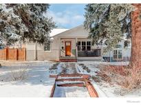 Charming bungalow featuring a quaint front porch, complemented by mature trees and a snow-covered yard at 941 8Th St, Boulder, CO 80302