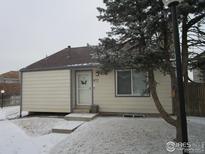 Charming single-story home with a cozy front entrance and snowy yard at 972 S Zeno Way, Aurora, CO 80017