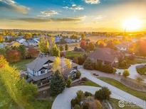 Stunning aerial view of luxury homes with circular driveways, surrounded by colorful fall foliage at sunset at 1574 Carlson Ave, Erie, CO 80516