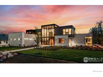 Striking modern home with unique architecture, stone accents, and expansive windows at sunset at 1590 Sumac Ave, Boulder, CO 80304