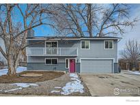 Charming two-story home boasts a balcony, attached two-car garage, and a welcoming pink front door at 1714 Zeus Dr, Lafayette, CO 80026