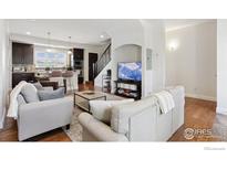 Open-concept living room flows into the kitchen with bar seating and hardwood floors throughout at 1944 Arapahoe Ave # C, Boulder, CO 80302