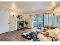 Bright living room with a fireplace, modern furniture, and sliding glass doors to the outside patio at 60 S Boulder Cir # 6015, Boulder, CO 80303