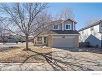 Charming two-story home with a well-maintained lawn and attached two-car garage at 6924 Quigley Cir, Firestone, CO 80504