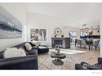 Bright living room featuring a fireplace, modern furniture, and light wood floors at 6924 Quigley Cir, Firestone, CO 80504