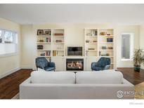 Bright living room featuring a cozy fireplace and built-in shelving for storage and decor at 780 Utica Ave, Boulder, CO 80304