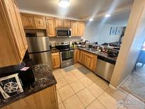 The eat-in kitchen features wooden cabinets, stainless steel appliances, and tile flooring at 805 29Th St # 204, Boulder, CO 80303