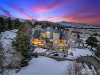 Captivating two-story home with stone accents, a turret, and mountain views at sunset at 8400 Middle Fork Rd, Boulder, CO 80302