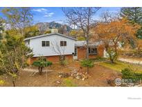 Charming raised ranch with mature trees, brick accents, and mountain views at 845 Hartford Dr, Boulder, CO 80305