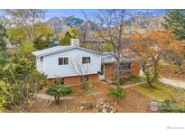 Charming light blue, split-level home with brick facade and mountain views at 845 Hartford Dr, Boulder, CO 80305