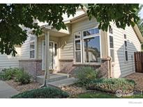 Charming home featuring a brick facade, lovely landscaping, and a welcoming front entrance framed by lush trees at 924 Parker Dr, Longmont, CO 80501