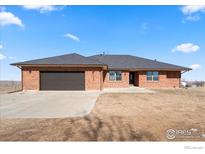 Lovely ranch-style home featuring a brick facade, attached garage, and well-maintained landscaping in a tranquil neighborhood at 11837 County Road 39, Fort Lupton, CO 80621