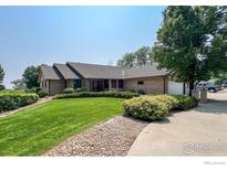 Charming single-story brick home with well-manicured lawn and mature trees at 1314 Highway 66, Longmont, CO 80504