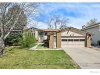 Charming home featuring a lush green lawn and attached two car garage at 1460 Harvard St, Longmont, CO 80503