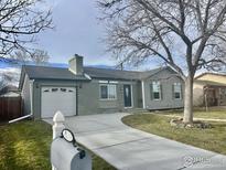 Charming ranch-style home with a well-maintained lawn and a lovely curved driveway at 1737 Dexter St, Broomfield, CO 80020