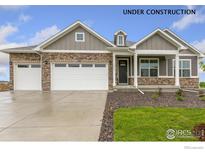 Charming home featuring stone accents, three-car garage, and landscaped front yard at 1818 Sawtooth Mountain Dr, Berthoud, CO 80513
