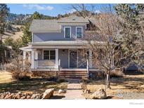 Charming two-story home with a covered front porch and stone accents, surrounded by mature trees at 3561 4Th St, Boulder, CO 80304