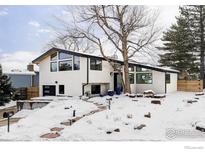 Stunning modern home featuring sleek lines and a beautiful snowy front yard with mature tree at 3590 Longwood Ave, Boulder, CO 80305