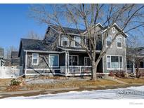 Charming gray two-story home featuring a welcoming front porch and well-maintained landscaping at 4008 Ravenna Pl, Longmont, CO 80503