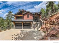 Stunning home with stone accents, a two-car garage, and inviting stairs to the front door at 795 Pine Brook Rd, Boulder, CO 80304