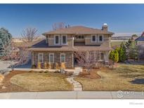 Charming two-story home featuring stone accents, landscaped front yard, and a welcoming walkway at 1244 Hawk Ridge Rd, Lafayette, CO 80026