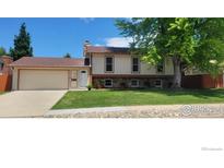 Charming two-story home with a well-manicured front yard and mature tree at 2042 Garfield Ave, Louisville, CO 80027