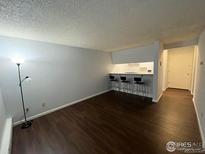Cozy living room features hardwood floors and a breakfast bar with seating at 2707 Valmont Rd # 111A, Boulder, CO 80304