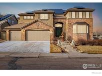 Attractive two-story home featuring a three-car garage, brick accents, solar panels, and manicured landscaping at 301 Amethyst Way, Superior, CO 80027