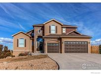 Two-story home featuring a beautiful stone and stucco exterior with a three-car garage and landscaped front yard at 3214 Timeless Trl, Berthoud, CO 80513