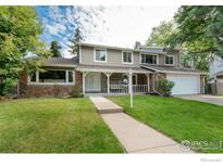 Charming two-story home with a manicured lawn, stone accents, and a welcoming front porch at 6146 S Fulton St, Englewood, CO 80111