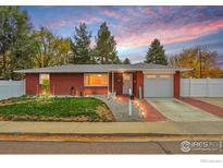 Charming brick home with manicured lawn, walkway lighting, and a one-car garage at 1211 16Th Ave, Longmont, CO 80501