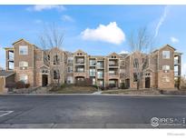 Attractive multi-Gathering residence featuring stone accents, balconies, and well-maintained landscaping at 2800 Blue Sky Cir # 208, Erie, CO 80516