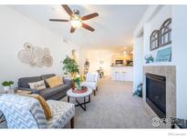 Inviting living room with a fireplace, neutral decor, and an open layout to the kitchen and dining area at 3100 Blue Sky Cir # 205, Erie, CO 80516