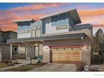 Modern two-story home featuring a stylish design with blue and white accents and an attached wooden two-car garage at 3633 Paonia St, Boulder, CO 80301