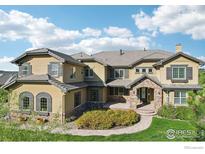 Stunning home exterior with stone accents, manicured lawn, and mature landscaping creating a welcoming curb appeal at 4873 Desperado Way, Parker, CO 80134