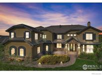Stunning exterior of a luxury home with stone accents, dark shutters, and beautiful landscaping under a twilight sky at 4873 Desperado Way, Parker, CO 80134