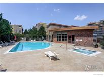 Community pool and spa with sun loungers, surrounded by mature landscaping near the resident clubhouse at 9039 E Panorama Cir # 201, Englewood, CO 80112