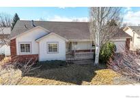 Charming single-story home with a brick and siding exterior, covered porch, and mature landscaping at 1121 Jefferson Dr, Berthoud, CO 80513