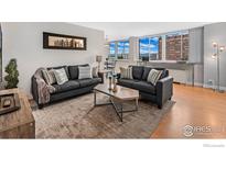 Bright living room with couches, hardwood floors, and expansive windows with great city views at 1196 N Grant St # 710, Denver, CO 80203