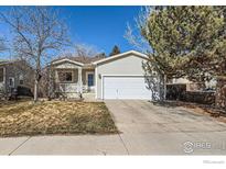 Charming home with a well-manicured lawn, inviting front porch, and a two-car attached garage at 1215 Monarch Dr, Longmont, CO 80504