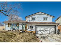 Charming two-story home featuring a covered front porch with rocking chairs and a well-maintained front yard at 1317 S Terry St, Longmont, CO 80501