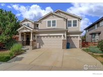 Charming two-story home with a three-car garage and stone accents on the facade at 15453 E 109Th Ave, Commerce City, CO 80022