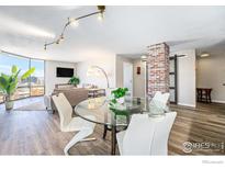 Open living room featuring modern decor, hardwood floors, and large windows with panoramic views of the cityscape at 1625 Larimer St # 2501, Denver, CO 80202