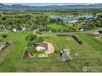 Stunning aerial view of a country home, featuring a spacious lawn and beautiful mountain views in the background at 1866 Park Lake Dr, Boulder, CO 80301